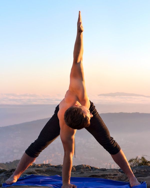 Man stretching outdoors at sunrise, symbolizing harmony and flexibility.